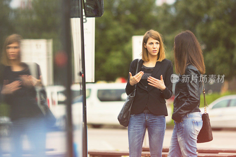 Young women waiting on the bus station